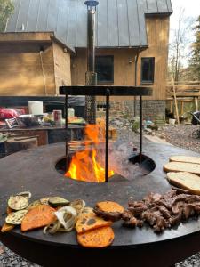 una griglia con carne, hamburger e un caminetto di Chalet FiMiLi a Vyšná Boca