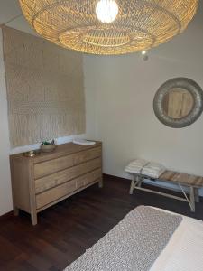 een slaapkamer met een houten dressoir en een kroonluchter bij Under the Tower in Pisa
