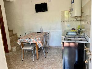 Aires de las Sierras في فيلا كارلوس باز: مطبخ مع طاولة مع كراسي وموقد