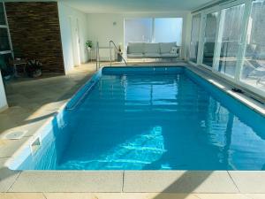 a swimming pool with blue water in a house at La Romély in Arzier