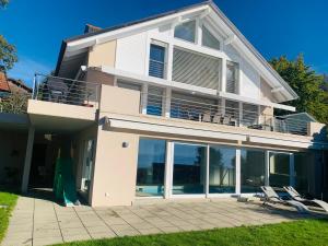 a house with large windows and a patio at La Romély in Arzier