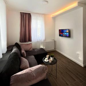 ein Wohnzimmer mit einem Sofa und einem Tisch in der Unterkunft Apartmani Divila in Divčibare