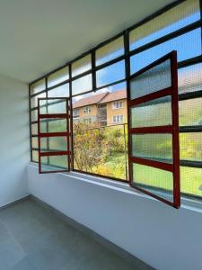 a room with two large windows in a building at FLH - Nana's apartment in Sibiu
