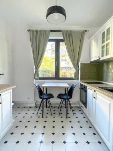 a kitchen with a table and chairs and a window at FLH - Nana's apartment in Sibiu