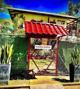 una valla con techo rojo delante de una casa en BUDDA HOME, en Tortuguero