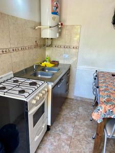 una pequeña cocina con fogones y fregadero en Aires de las Sierras 2, en Villa Carlos Paz