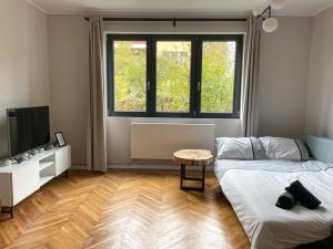 a room with two beds and a tv and a table at FLH - Nana's apartment in Sibiu