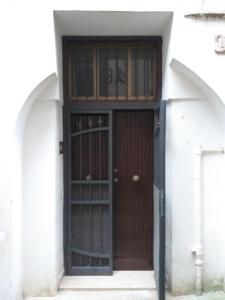 una entrada a un edificio blanco con una puerta marrón en La Casa di Lina en Sezze