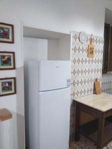 um frigorífico branco numa cozinha com uma mesa em La Casa di Lina em Sezze