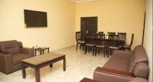 a living room with a couch and a table and chairs at Extended Stay Suite in Adentan