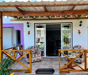 a porch with two chairs and a table at POSADA VILLA BRYAN in Providencia