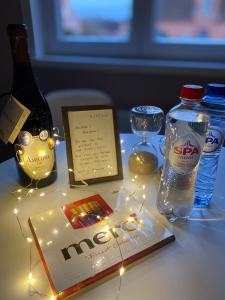 una mesa cubierta con una botella de agua y luces en Vakantiestudio Ouanaïo en Zedelgem