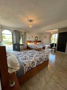ein großes Schlafzimmer mit 2 Betten und einem Sofa in der Unterkunft Casa Lomas Grangelo in Atlixco