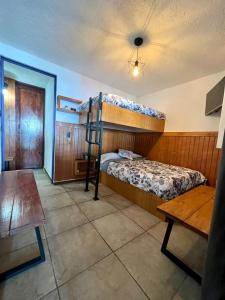 Casa Lomas Grangelo في أتليكسكو: غرفة نوم بسريرين بطابقين وطاولة