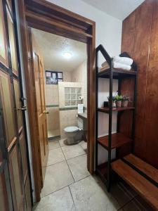 a bathroom with a toilet and a sink and a door at Casa Lomas Grangelo in Atlixco