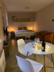 una camera d'albergo con un letto e due tavoli e sedie di Vakantiestudio Ouanaïo a Zedelgem
