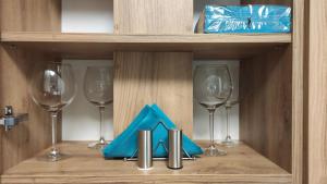 ein Regal mit Weingläsern und einer blauen Serviette in der Unterkunft Apartament "Marianki" Jagiełły 3 in Świecie