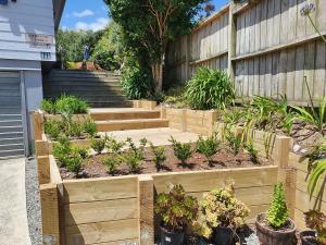 a garden with wooden steps and plants at Pohutukawa Lodge by Orewa Beach in Orewa