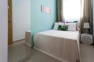 a small bedroom with a bed with a window at Apartamentos Diaber San Leandro in Seville