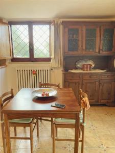 uma cozinha com uma mesa e cadeiras de madeira e janelas em Deliziosa Villa Panoramica em Campagnano di Roma