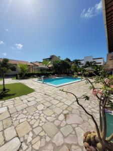 a stone walkway leading to a swimming pool at Pousada Águas de Serrambi in Porto De Galinhas