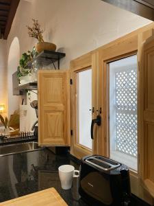 una cocina con armarios de madera y un aparato negro en Loft Xera - parking privado, en Jerez de la Frontera