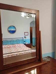 a mirror reflecting a bed in a bedroom at Locanda Miranda in Tellaro