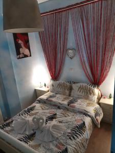 Frasta's Rose في Plaka: غرفة نوم بسرير مع ستائر حمراء