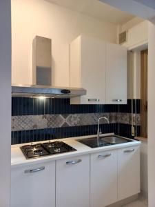 a white kitchen with a stove and a sink at CASA GINEVRA in Silvi Marina