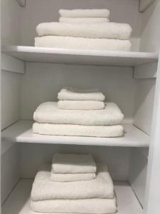 Armario blanco con toallas blancas en los estantes en Central Frisco - renovated nice & cozy unit 3 bed & 2 bath - free wifi & parking, en Frisco
