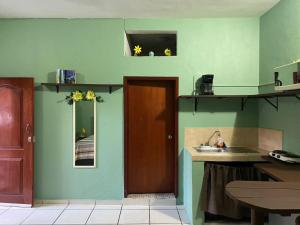 cocina con paredes verdes, puerta y fregadero en Appartamenti Melissa, en Playa del Carmen