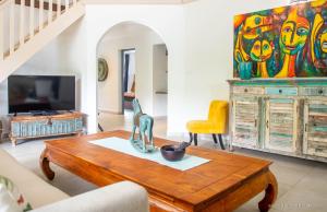 a living room with a table and a tv at VILLA « FLEUR DE PIRATE » in Saint Martin