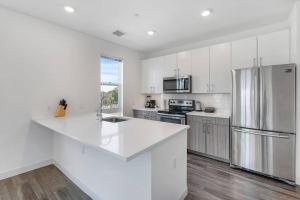 een keuken met witte kasten en een koelkast bij Spacious sunny 2Br2Ba apartment in Boston