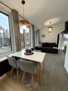 een woonkamer met een witte tafel en stoelen bij Salt Garden Superior double rooms in Druskininkai