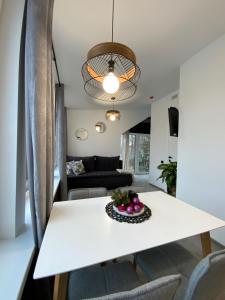 a white dining room table with a bowl of fruit on it at Salt Garden Superior double rooms in Druskininkai