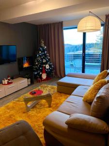 a living room with a christmas tree and a couch at Happy Place in Poiana Brasov