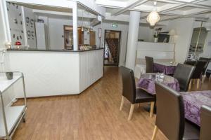 a restaurant with tables and chairs and a counter at Hotell Linden in Östersund