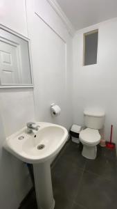 uma casa de banho com um lavatório branco e um WC. em Casa Barros Borgoño em Valparaíso