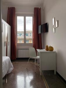 Schlafzimmer mit einem Schreibtisch, einem Bett und einem Fenster in der Unterkunft CASA AMEDEO in Genua
