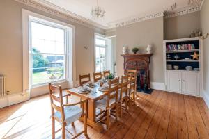 a dining room with a table and chairs and a fireplace at The Manor Holcombe Luxury House Pool & Hot-tub in Holcombe