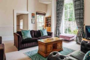 a living room with a couch and a coffee table at The Manor Holcombe Luxury House Pool & Hot-tub in Holcombe