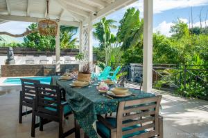 a dining table and chairs on a patio at VILLA « FLEUR DE PIRATE » in Saint Martin
