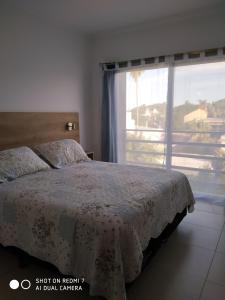 ein Schlafzimmer mit einem Bett und einem großen Fenster in der Unterkunft Departamentos Reibel in Colón