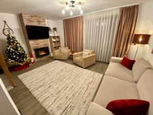 ein Wohnzimmer mit einem Weihnachtsbaum und einer weißen Couch in der Unterkunft Dream Studio Silver Mountain in Poiana Brașov