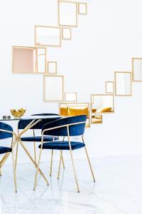 uma sala de jantar com cadeiras azuis e uma mesa em Thome Exclusive Cuvee Turda em Turda