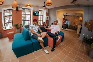 Dois homens sentados num sofá na sala de estar. em Viajero Cartagena Hostel em Cartagena das Índias