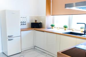 a white kitchen with a refrigerator and a sink at Thome Exclusive Cuvee Turda in Turda