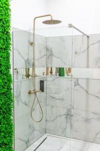 uma casa de banho com chuveiro e mármore branco em Thome Exclusive Cuvee Turda em Turda