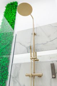 eine Messingbodenlampe im Bad mit grüner Hecke in der Unterkunft Thome Exclusive Cuvee Turda in Turda