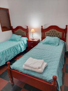 1 dormitorio con 2 camas y toallas. en Cactus del Valle en Tinogasta